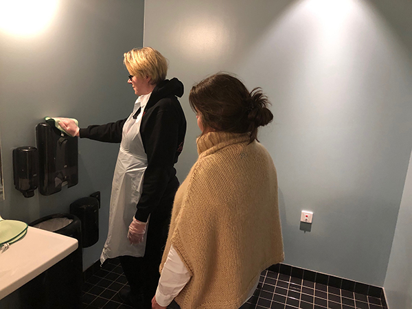 Maria Edvardsen har ett praktiskt utbildningsmoment med en deltagare i toalettstädning